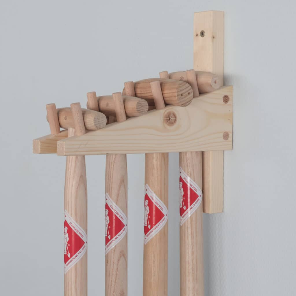 Houten rek met handgesmeed tuingereedschap in ophangsysteem